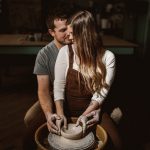 A man and a woman sit together at a pottery wheel re-enacting the intimate pottery scene from the movie, "Ghost".